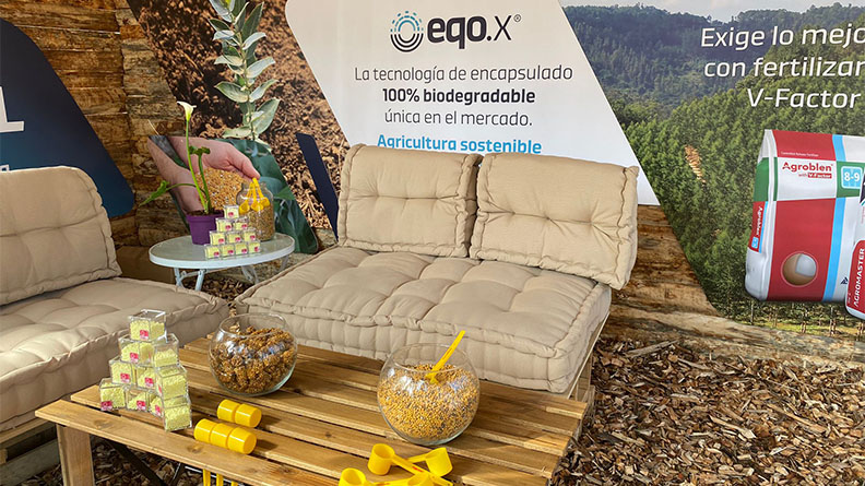 ICL’s sustainable forestry event stand featuring comfortable seating, eco-friendly displays, and promotional materials for biodegradable fertilizer technology eqo.x. The setup includes recycled wooden furniture and natural décor, highlighting sustainable agriculture practices.