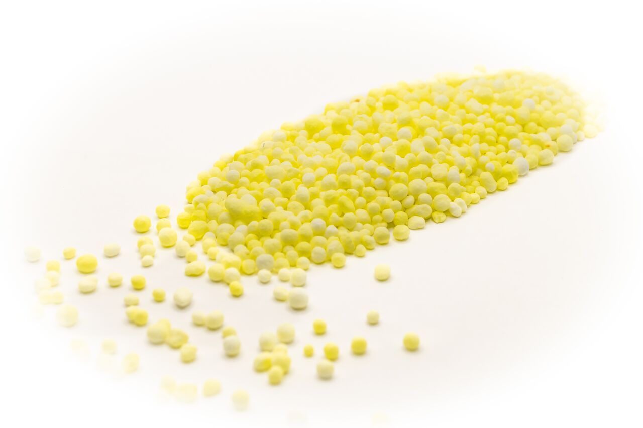 Close-up of Agrocote controlled-release fertilizer granules, showing bright yellow polymer-coated pellets designed for efficient nutrient release and sustainable crop growth.